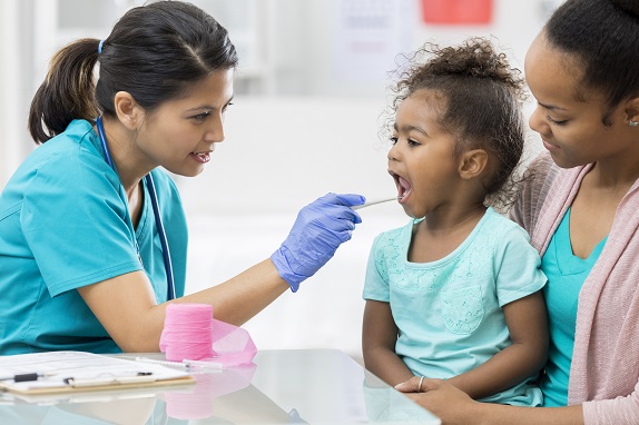 A nurse practitioner examining a young patient