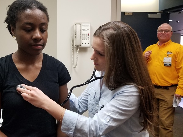 Prof. Newman observes a student practitioner examining a patient