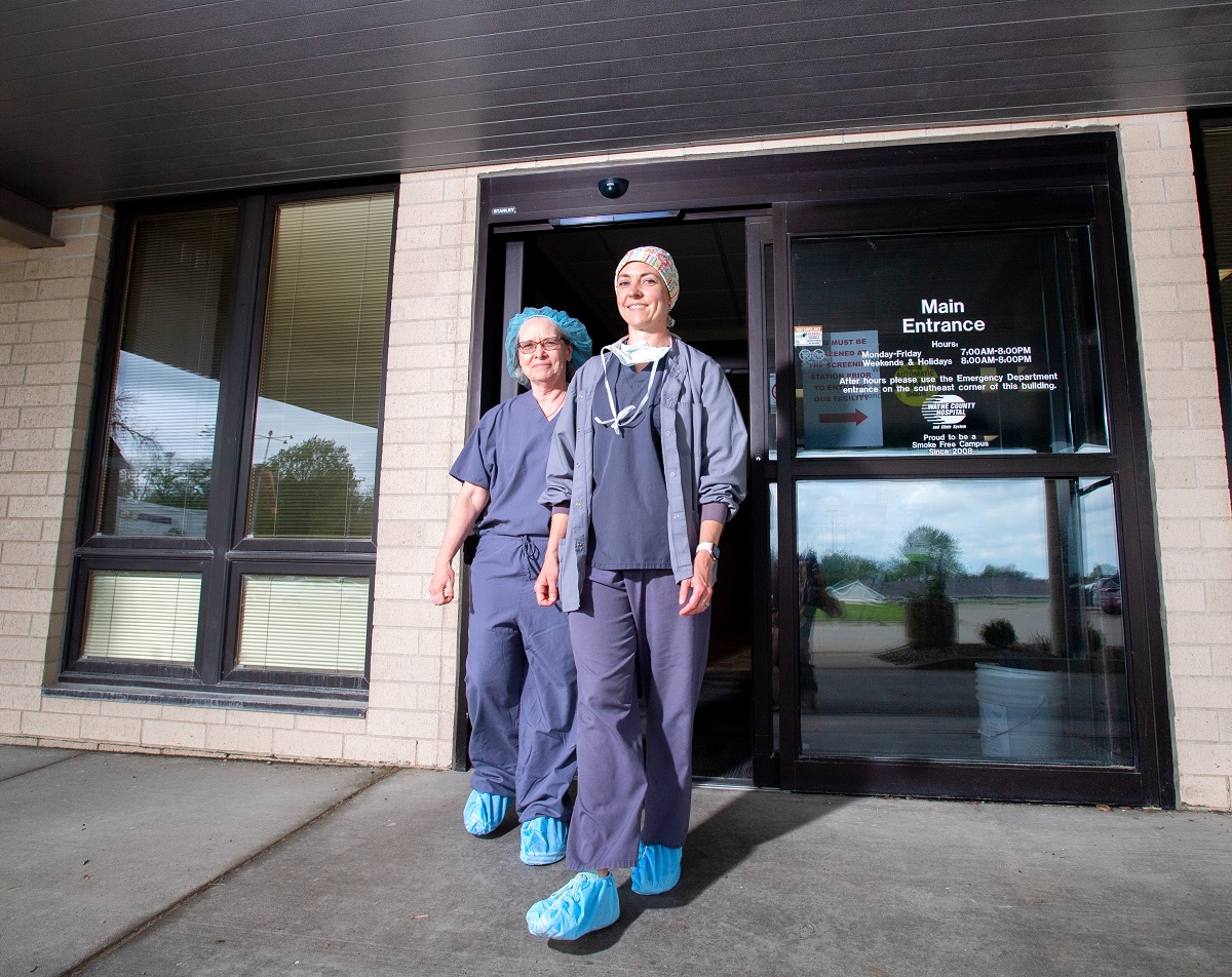 Two nurses walking out of a building