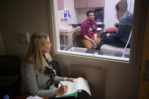 Vanessa Kimm observing student nurse interact with a simulated patient