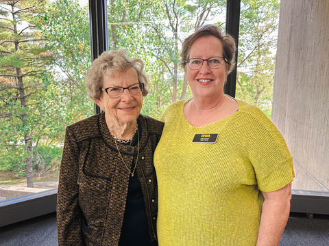 Mardella Carlson and Julie Zerwic stand and smile for the camera. 