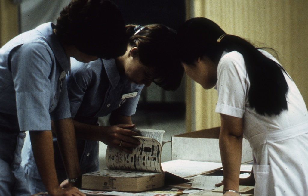 three students bent over text book