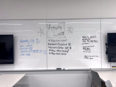 A white board with the words Activity Log written on it. Incidents reported, vaccinations given, and other data is tallied on the board. 