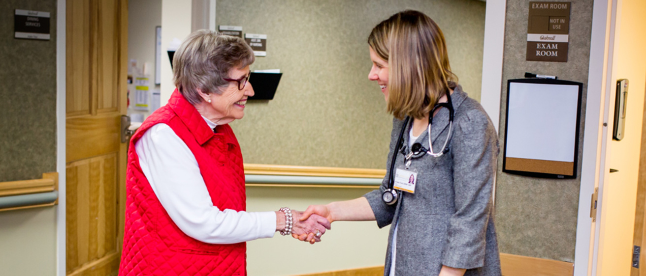 Prof. Krista Ford shaking hands with a patient