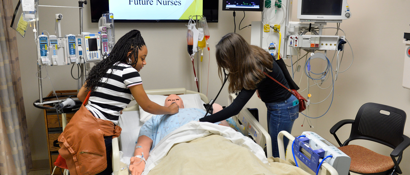 Two students in the nursing clinical simulation lab
