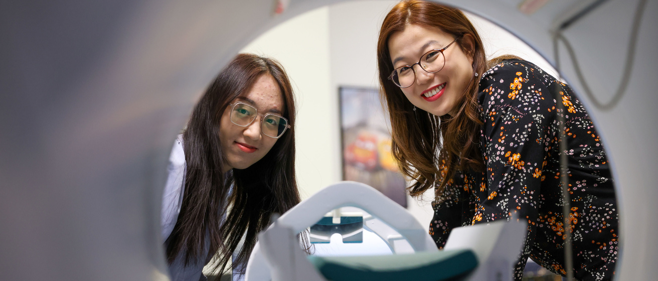 two women look through mri machine