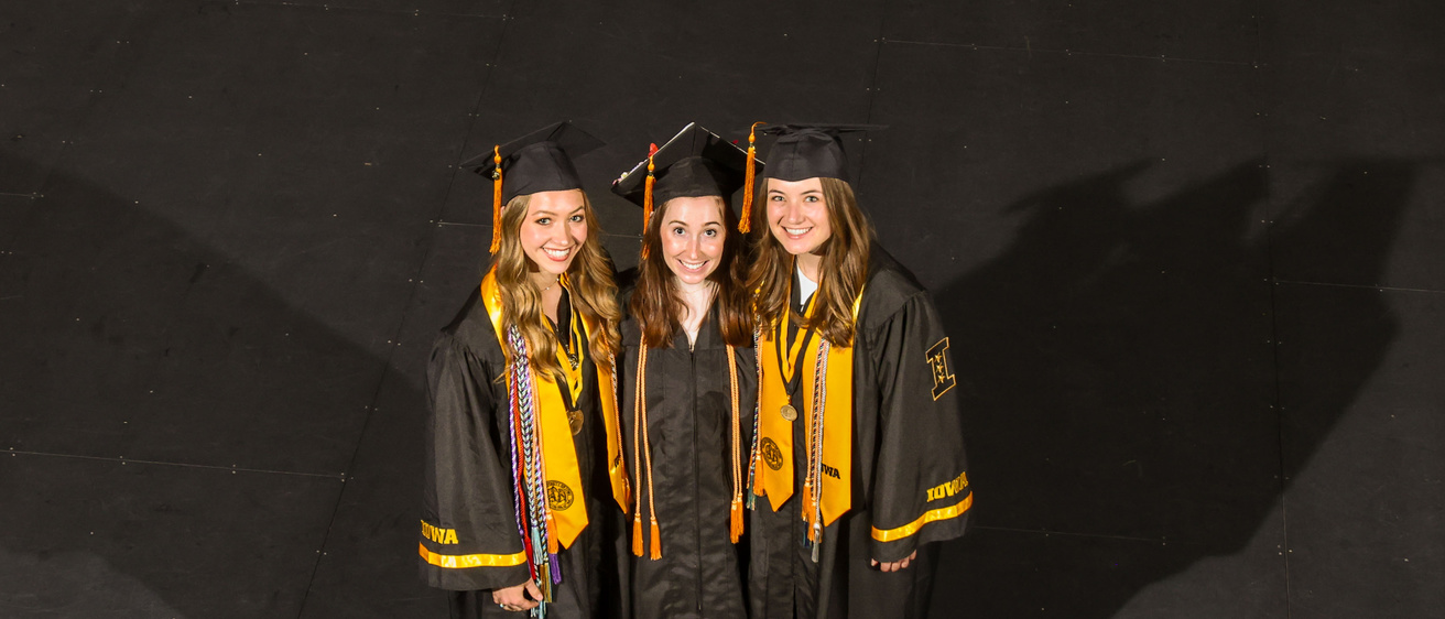 Three honors graduates post for a photo at commencement May 24