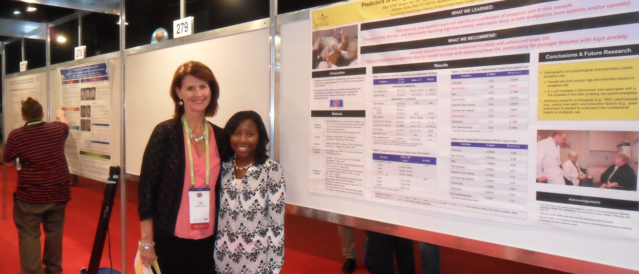 Keela Herr and Star Booker stand together in front of their poster at IASP. 
