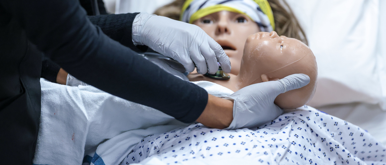 nurse arm sets baby manikin on mother manikin