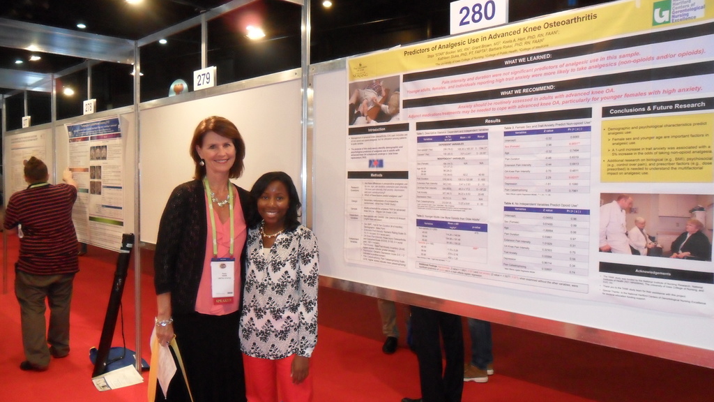 Keela Herr and Star Booker stand together in front of their poster at IASP. 