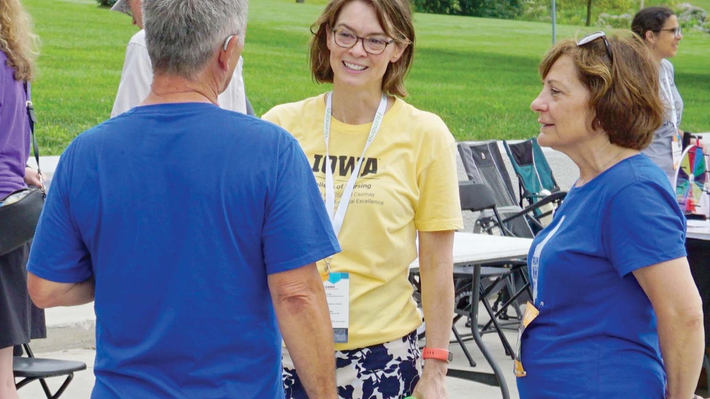 Three people talk in a small circle. 
